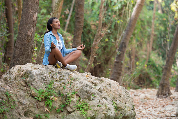 istock Young woman meditating in forest. 622978372