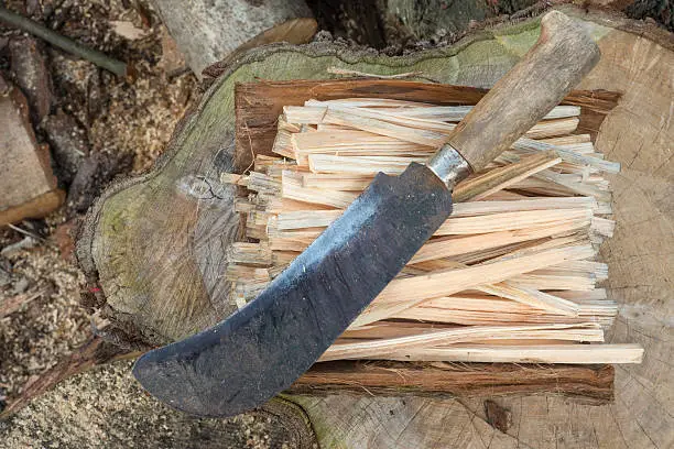 Photo of Overhead of a Machete on a Pile of Firewood Sticks