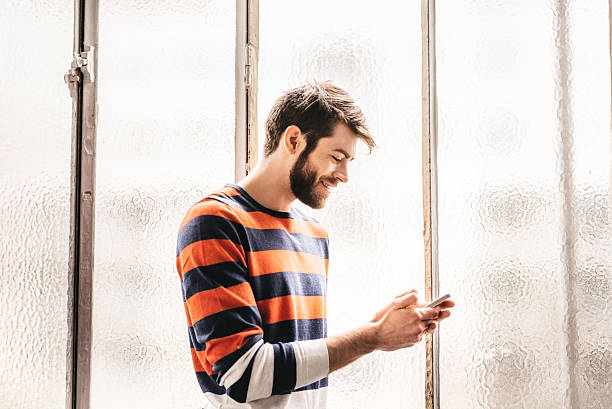 istock happy bearded young man looking at mobile in Paris loft 622979830