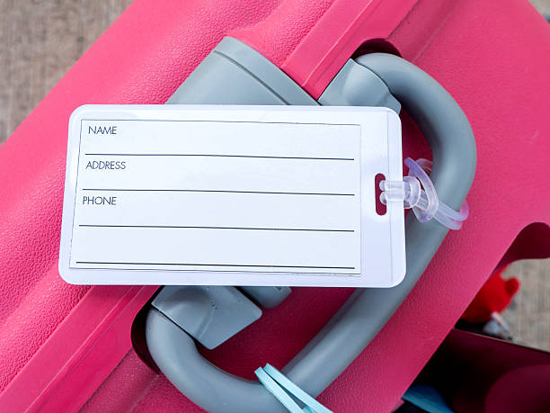 Luggage tag on pink suitcase 2 Closeup luggage tag on pink suitcase (Travel kit) luggage tag stock pictures, royalty-free photos & images