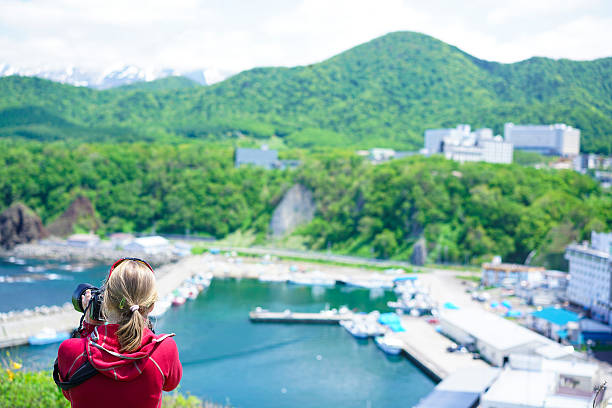 mujer mirando la costa de shiretoko en utoro, hokkaido japón - sea of okhotsk fotografías e imágenes de stock