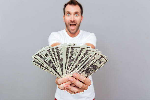 istock Happy casual man giving money on camera 622987196