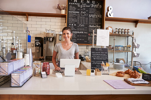Woman ready to serve behind the counter at a coffee shop