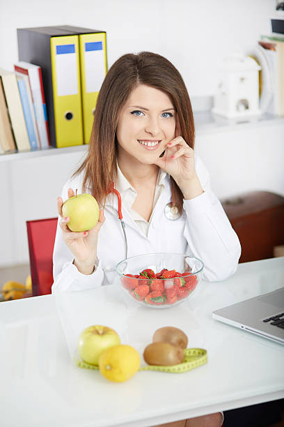 istock young nutritionist showing apple 622987568