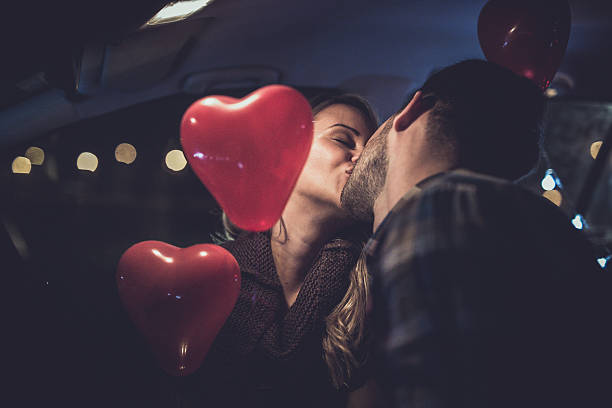 And to... Photo of loving young couple kissing in the car date night romance stock pictures, royalty-free photos & images