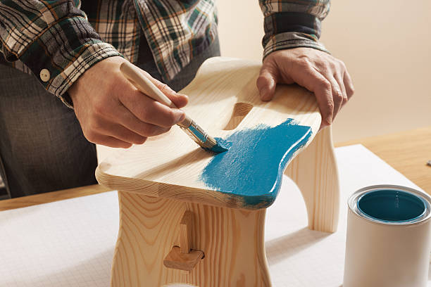 craftsman varnishing and handmade stool - carpenter restoring furniture wood imagens e fotografias de stock