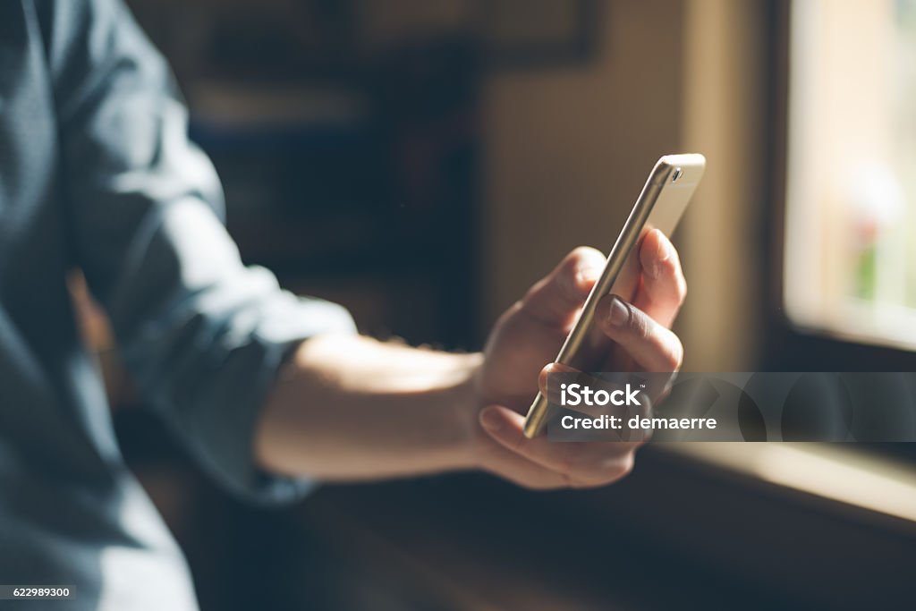 Young hipster using a mobile phone Hipster using a touch screen smart phone hands close up, vintage colors Smart Phone Stock Photo