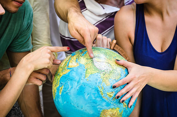 Front view of a child hand holding a damaged toy globe, shallow depth of field