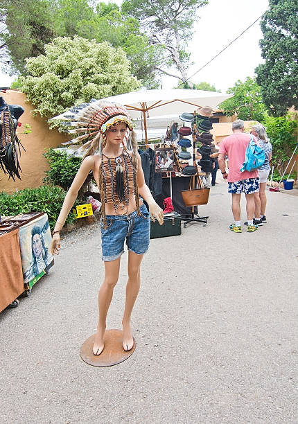 Es Canar, Ibiza, Balearic islands, Spain - October 26, 2016: Hippy Market fashion doll with Indian feather crown in Es Canar Punta Arabi on an overcast autumn day in October.