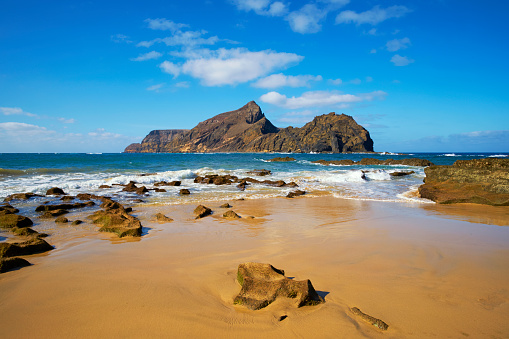 Looking out across a sandy beach on the island of Porto Santo towards the rugged islet known as Ilhéu da Cal.