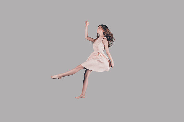 Her life in motion. Studio shot of attractive young woman hovering in air levitation stock pictures, royalty-free photos & images