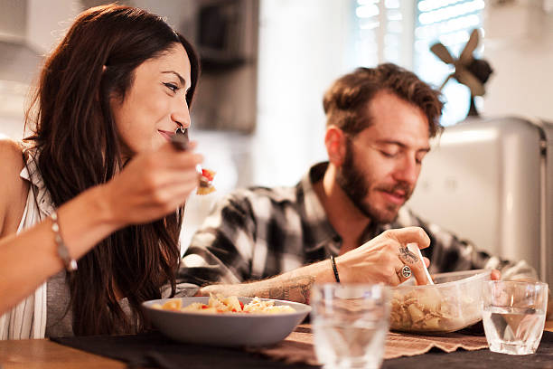 Young couple eating together at home