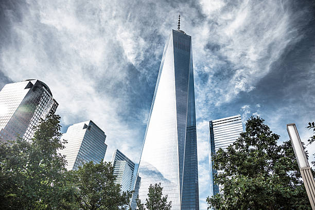 Skyscraper architectural details and structures in New York downtown, USA. Low angle view with lens flare and bright sun in the sky.