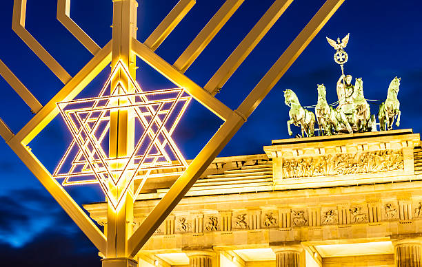 Brandenburger Tor behind illuminated menorah at Brandenburg Gate Building in Berlin. Shot in blue hour in a December evening 2020, Berlin, Germany