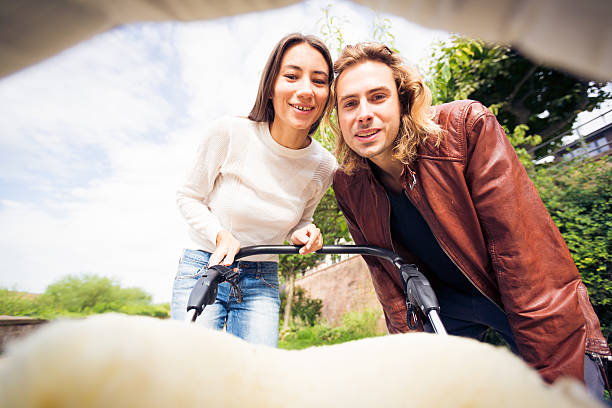 istock Young parents looking at their baby in a stroller 623060754