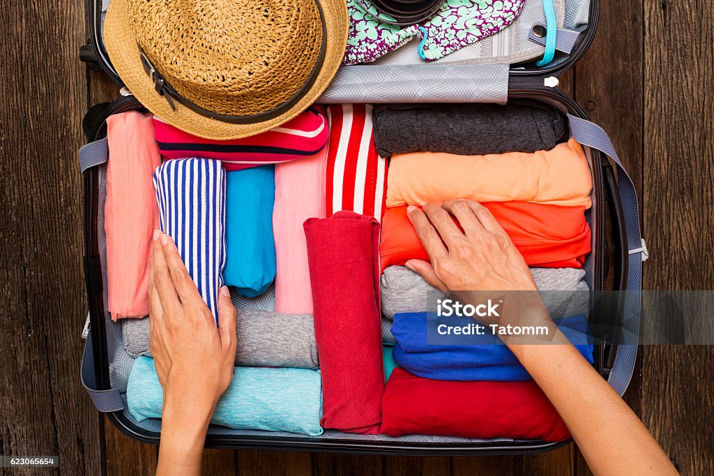 Mujer de embalaje un equipaje para un nuevo viaje - Foto de stock de Empaquetar libre de derechos