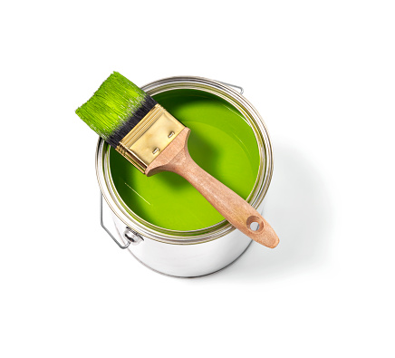 Green paint tin can with brush on top on a white background