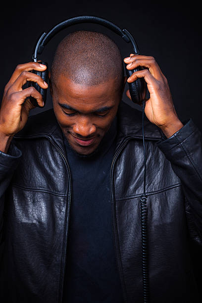 istock Young Black Man Wearing Leather Jacket Putting on Headphones 623068752