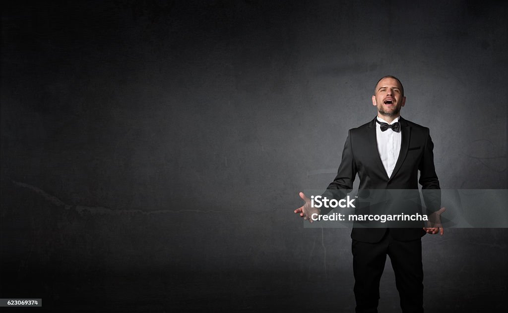 classical singer gestures with hands classical singer gestures with hands, dark background Opera Stock Photo