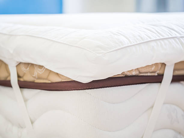 Closeup of white topper on the bed in the bedroom stock photo
