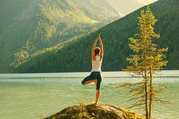 istock Young woman is practicing yoga at mountain lake 623091750