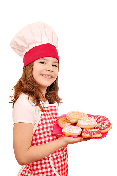 istock happy little girl cook with donuts 623094176