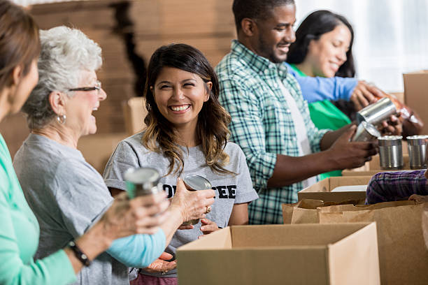 istock Volunteers pack canned goods into boxes during food drive 623095682