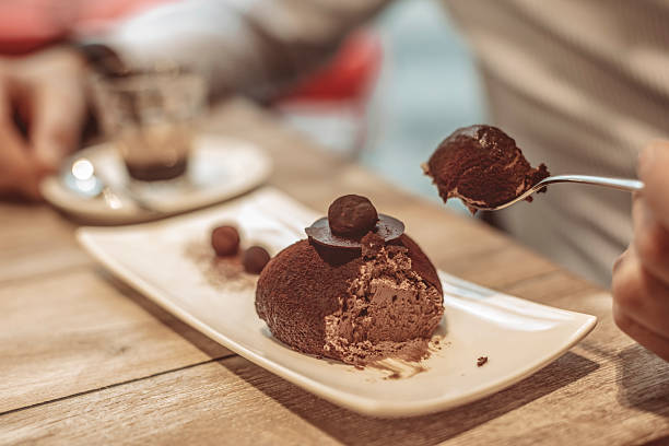 Young man eating chocolate cake Young man eating chocolate cake mushroom cookies stock pictures, royalty-free photos & images