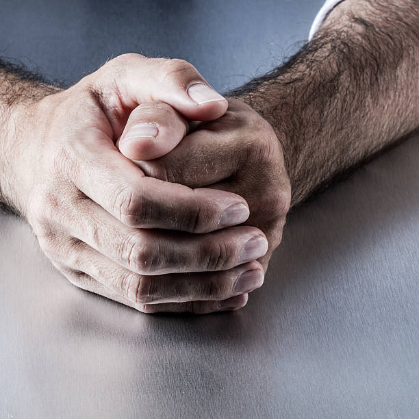 istock closeup, anonymous relaxed male hairy hands holding together on desk 623097150