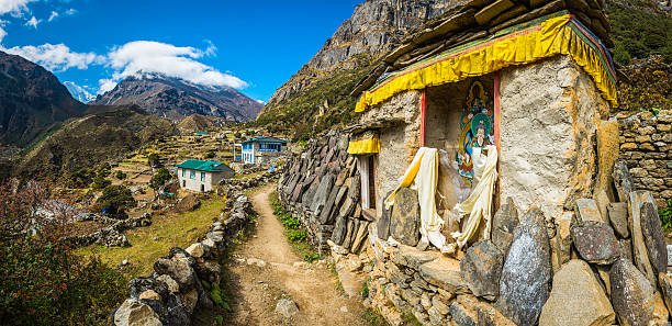 Buddhist shrine mani stones mountain trail Sherpa village Himalayas Nepal Buddhist shrine and Mani Stones carved with mantras beside an earth trail through a Sherpa village in the remote Thame valley of the Everest National Park of the Khumbu Himalaya mountains, Nepal. single lane road footpath dirt road panoramic stock pictures, royalty-free photos & images