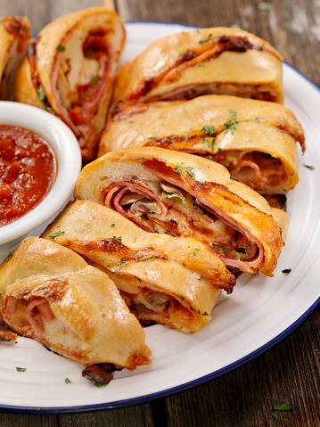 Authentic Hand Made Italian Stromboli with Pepperoni, Salami, Mushrooms and Peppers, Fresh Parmesan and Marinara Sauce  - Photographed on a Hasselblad H3D11-39 megapixel Camera System
