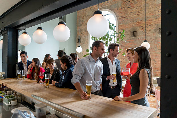 personas tomando bebidas en un restaurante - eventos sociales despues del trabajo fotografías e imágenes de stock