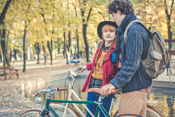 istock Young couple enjoying romantic ride with bicycle in autumn park 623104400