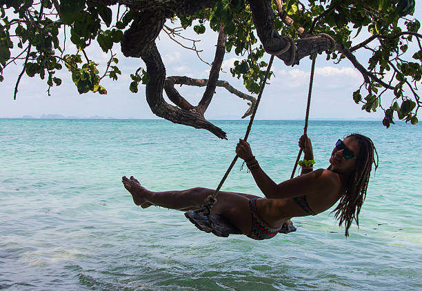 istock Girl sitting on the swing, tropical beach 623104402