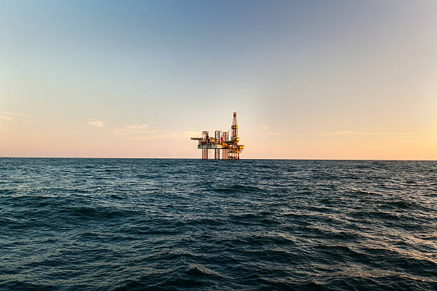 offshore jack up rig au coucher du soleil - sunset oil rig oil industry energy photos et images de collection