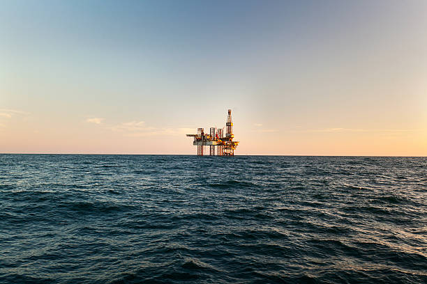 offshore jack up rig o zachodzie słońca - oil rig sea oil industry oil zdjęcia i obrazy z banku zdjęć