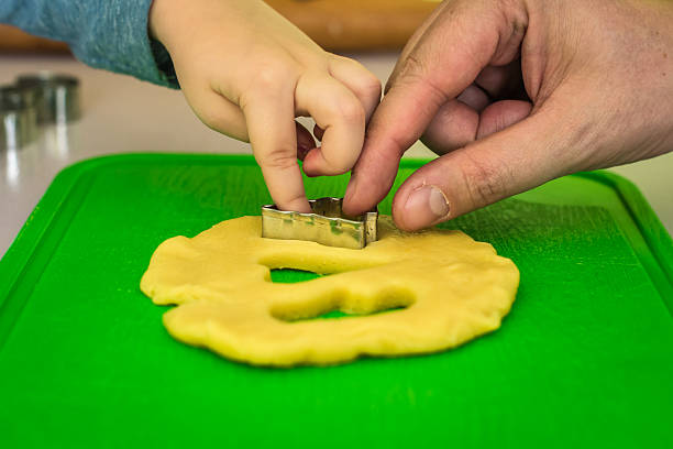kind und papa macht teig ausstecher - baking dough human hand rolling pin stock-fotos und bilder