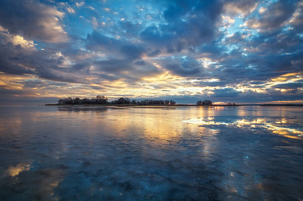 istock Winter landscape with river, reeds and cloudy sunset sky 623105824