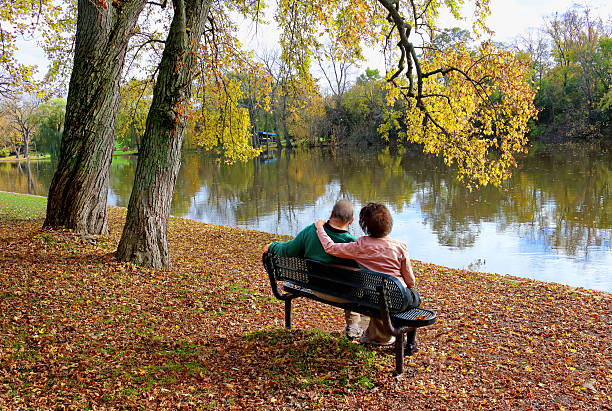 istock couple sitting on outdoor bench in autumn 623110966