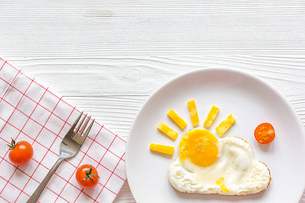 sunshine fried eggs breakfast for kid on wooden background