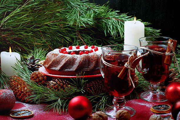 Christmas table setting. Bundt cake pudding sprinkled with sugar powder decorated with and mulled wine.