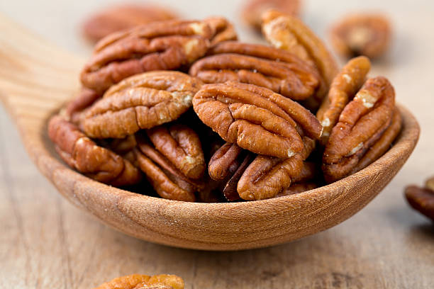 istock pecan nuts in a wooden spoon 623113920