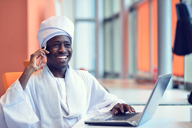 Sudanese business man in traditional outfit using mobile phone Sudanese business man in traditional outfit using mobile phone in office. khartoum stock pictures, royalty-free photos & images