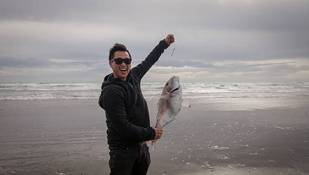 człowiek złapał ryby. - murawai beach zdjęcia i obrazy z banku zdjęć