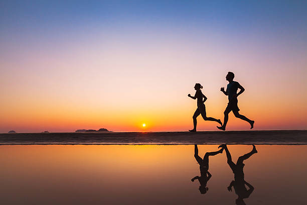entrenamiento, siluetas de dos corredores en la playa - family sport exercising jogging fotografías e imágenes de stock