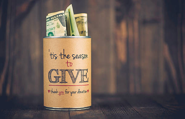Charity collecting tin against wooden background. American holiday fundraising
