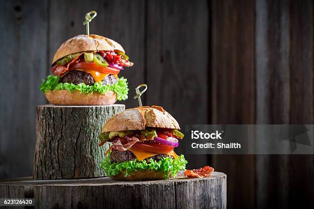 Two Burger With Onion Tomato And Lettuce Chips And Bacon Stock Photo - Download Image Now