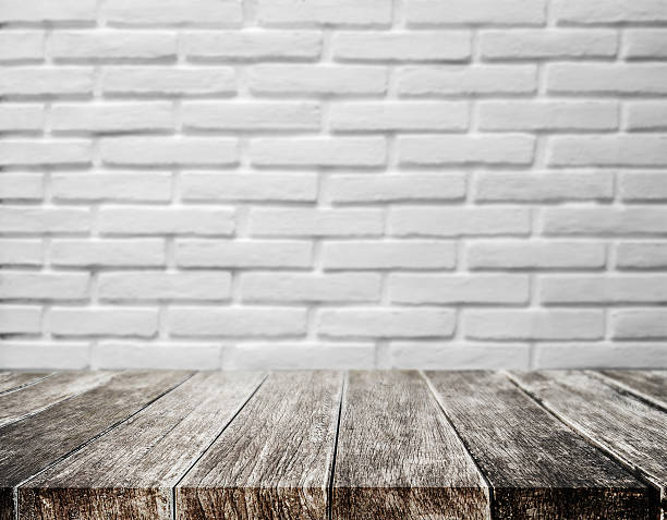 istock Wood plank tabletop, with defocus brick white wall texture background 623126488