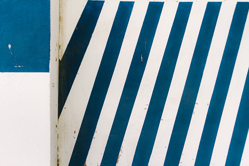 Wall painted with diagonal blue and white stripes and column