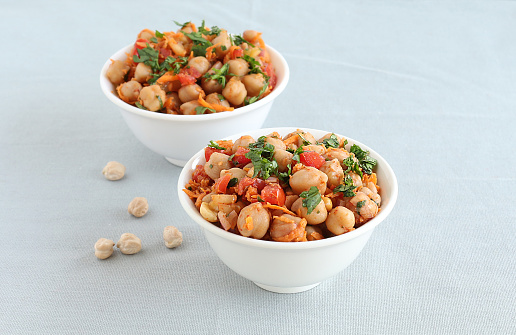 Indian vegetarian food channa chat, also known as chickpea or garbanzo curry, is eaten as a snack or is used as a side dish, in two bowls.